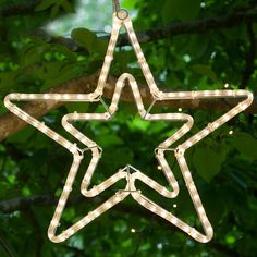 a lighted star ornament hanging from a tree branch in the shape of a star