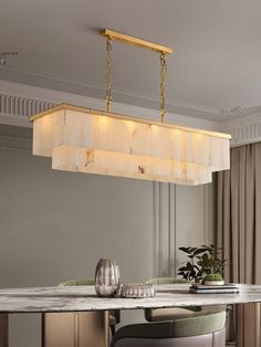 a dining room table with chairs and a chandelier hanging from it's ceiling