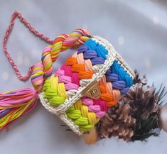 a multicolored handbag sitting on top of a table next to pine cones