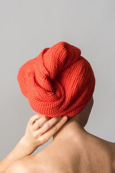 a woman with her back turned to the camera, wearing an orange knitted hat