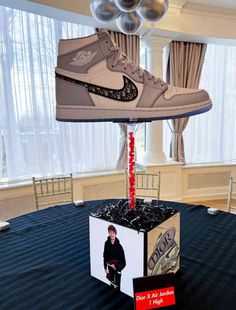 a pair of air jordans are on display in a room with balloons and curtains