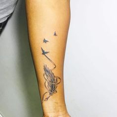 a woman's arm with an arrow and birds tattoo on the left side of her leg