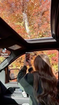 a woman taking a photo in the back seat of a car