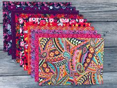 four different colored bandannas sitting on top of a wooden table