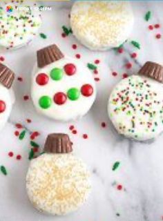 decorated cookies with frosting and sprinkles are arranged on a white surface