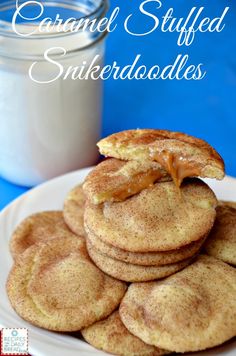 some cookies are stacked on top of each other with a jar of milk in the background