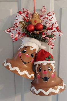 two christmas bells hanging from a door with candy canes and decorations on top of them