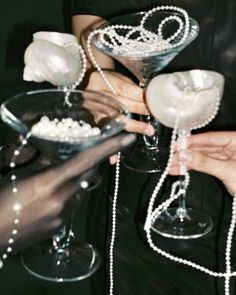 several people holding wine glasses with pearls on them