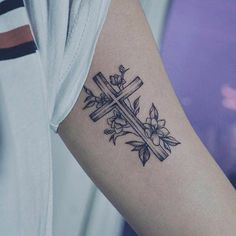 a cross with flowers and leaves on the left side of the arm is shown in black ink