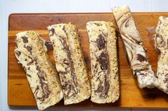 four pieces of food on a wooden cutting board