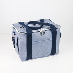 a blue and white striped bag sitting on top of a white table next to a wall