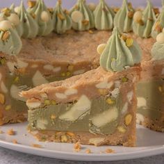 a piece of cake with green frosting and nuts on top is sitting on a plate