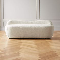 a white couch sitting on top of a hard wood floor