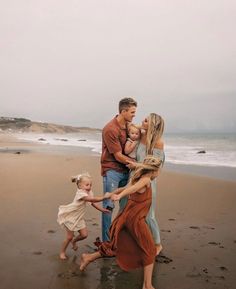 a family is playing on the beach together