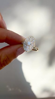 a hand holding a ring with a diamond in it