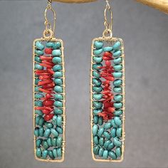 two pairs of turquoise and red beaded earrings hanging from a tree branch with gold earwires