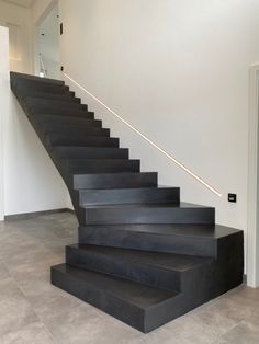 a set of black stairs in an empty room