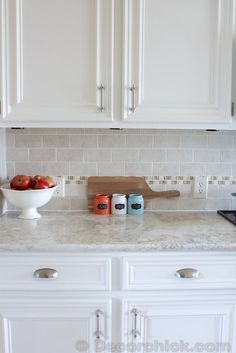 a bowl of apples sits on the kitchen counter