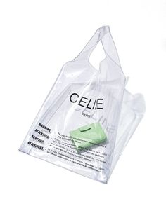 a clear plastic bag with a green shoe in the front and side of it on a white background