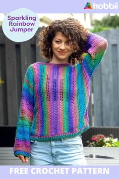 a woman wearing a colorful knitted sweater with the words sparkling rainbow jumper on it