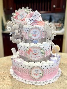 a baby shower cake with an elephant on top and other items around the cake,