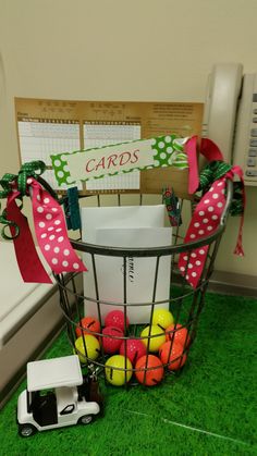 a basket filled with lots of balls on top of a green floor next to a white truck