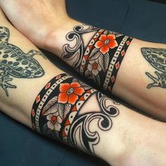 two people with tattoos on their legs and one has an orange flower in the middle