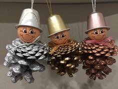 three ornaments are hanging from the ceiling with pine cones and hats on top of them