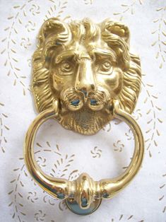 a gold lion head door knocket with screws