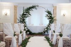 a wedding ceremony setup with white flowers and greenery