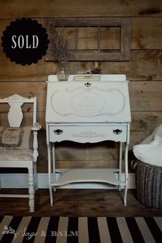 two chairs and a table in front of a wooden wall