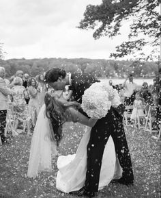 a bride and groom kissing in the middle of confetti