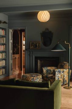 a living room filled with furniture and a fire place next to a book shelf full of books