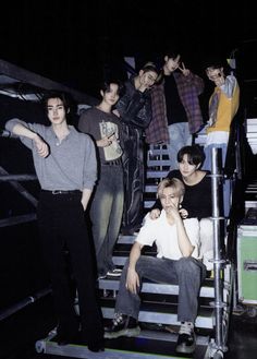 a group of young men standing on top of a stair case next to each other