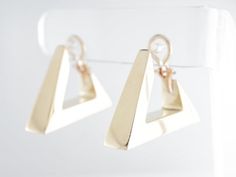 These fancy modern dangle earrings are finished in 14 karat yellow gold. They are secured by an omega closure and face forward for a good view of the triangle design from the side view. The triangles have lovely open spaces at the closure, existing as a design element as well as a functional space for wearing them.Composition: 14 Karat Yellow GoldGeneral Characteristics:Measurements: 1.5 inches x 8.19 mmTotal Gram Weight: 19.6Era: Modern 1970-PresentInscription: 14 KT--ALL PIECES ARE SUBJECT TO Modern Polished Clip-on Earrings For Anniversary, Modern Clip-on Huggie Earrings, Modern 14k Gold Dangle Hoop Earrings, Modern Yellow Gold Dangle Huggie Earrings, Modern Hallmarked Huggie Earrings, Modern Yellow Gold Clip-on Earrings With Polished Finish, Contemporary 14k Gold Earrings, Modern Yellow Gold Clip-on Earrings For Anniversary, Formal 14k Gold Dangle Huggie Earrings