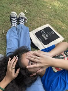 a woman laying on the ground holding her hands to her face