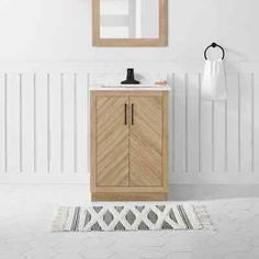 a bathroom with a sink, mirror and towel rack on the wall next to it