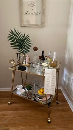 a gold bar cart with drinks on it