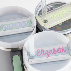 three personalized metal containers sitting on top of each other with name tags attached to them