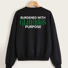 a black sweatshirt with the words surrounded with glorious purpose printed on it, hanging from a wooden hanger