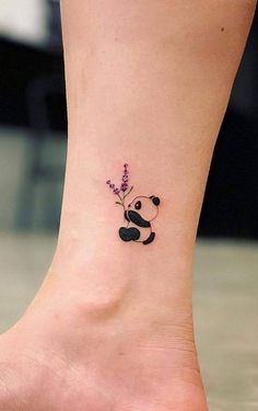 a small tattoo on the ankle of a woman with a panda bear and lavender flowers