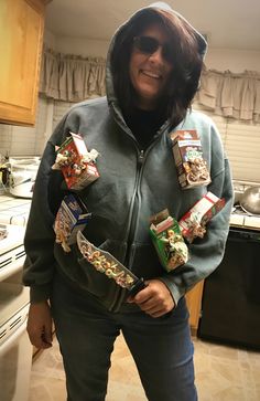 a woman in a hoodie with some snacks on her pocket and the hood pulled up