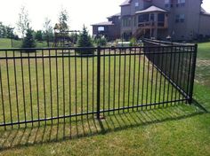 a black fence in front of a large house