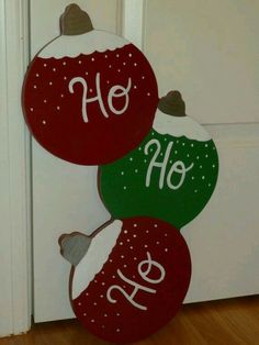 three red and green christmas ornaments hanging from the front door