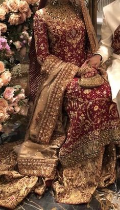 two people sitting next to each other in wedding outfits