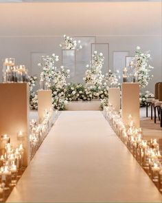 a wedding aisle with candles and flowers on the side for an elegant touch to the ceremony