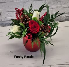 a red vase filled with flowers and greenery