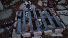 there is a bed made out of cement blocks with skulls on it and tombstones in the ground