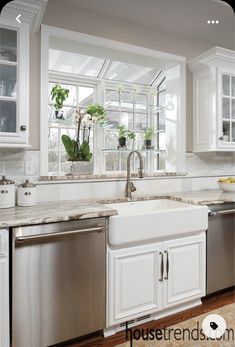 a kitchen with white cabinets and stainless steel dishwasher in the center, window over the sink