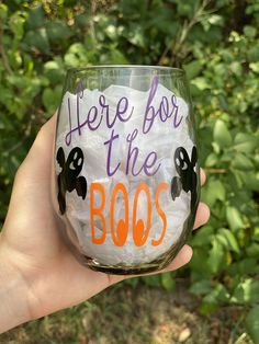 there is a hand holding a wine glass with the words here for the boos on it